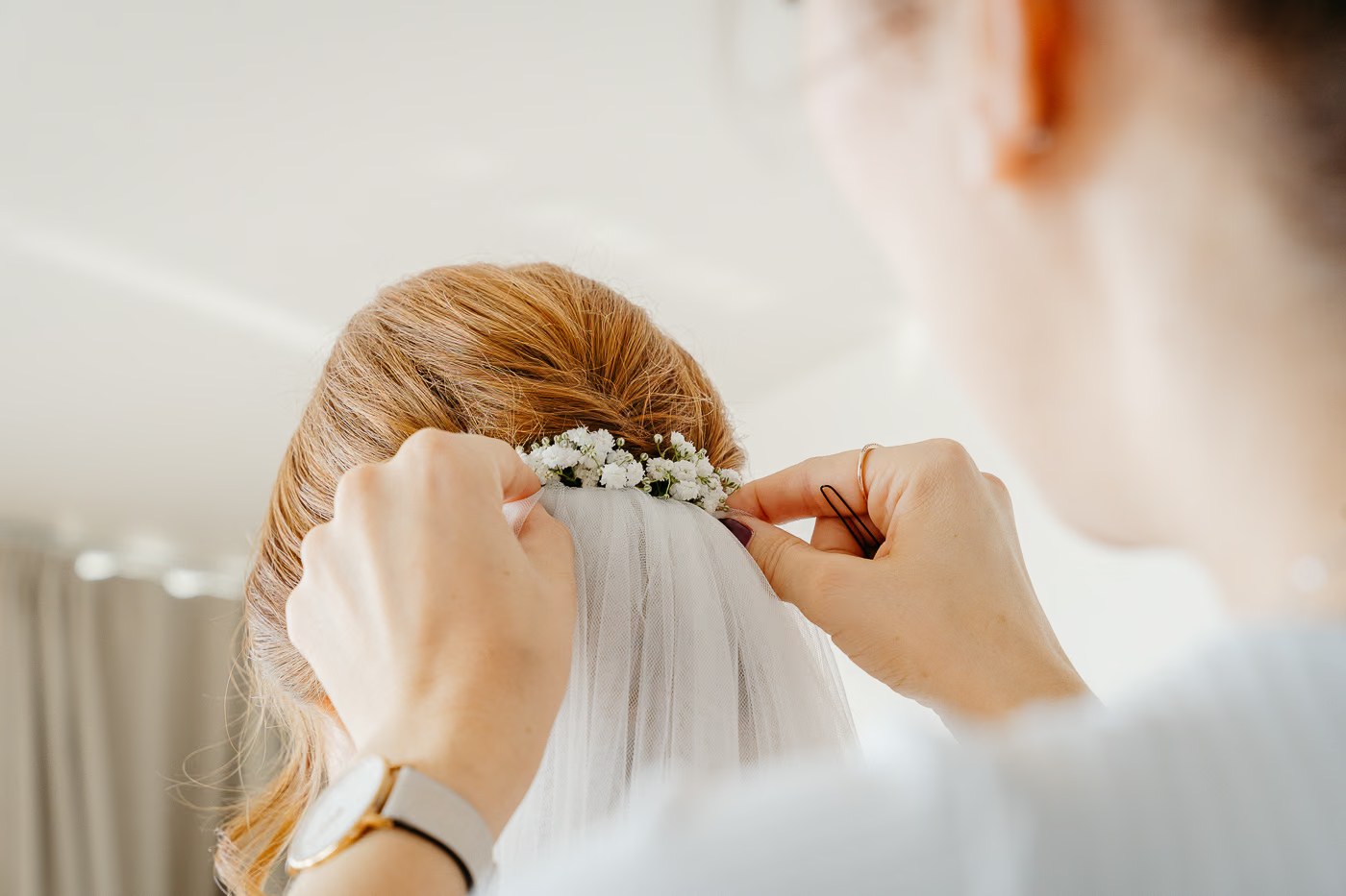 Getting Ready Hochzeit – Brautschleier wird mit Schleierkraut in die Hochzeitsfrisur gesteckt, zarter letzter Moment vor der Trauung, Hochzeitsfotos Gifhorn Kathrin Skorpel