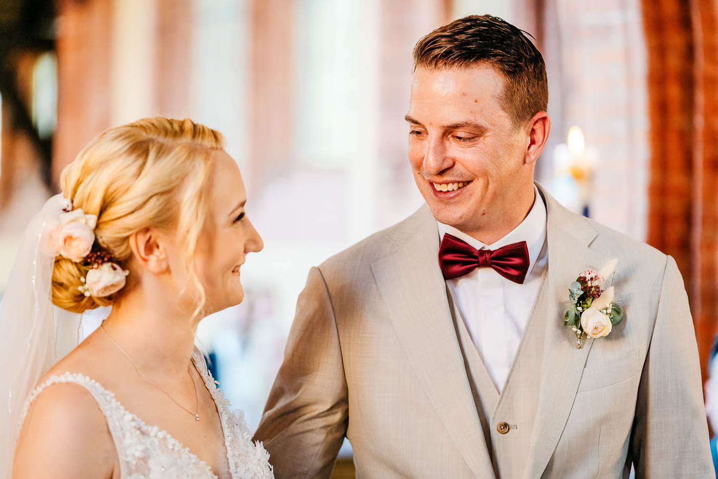 Kirchliche Trauung Gifhorn – Braut und Bräutigam schauen sich lachend an, strahlende Freude während der Trauung, natürliche Hochzeitsfotografie Gifhorn Kathrin Skorpel