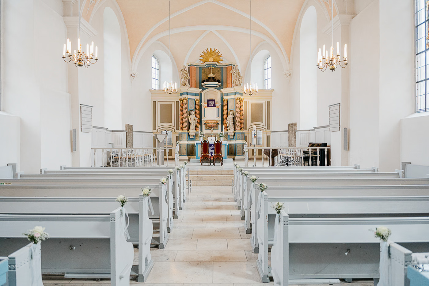 Kirchliche Trauung Helmstedt – Heller Kirchenraum mit weißen Bänken und floraler Hochzeitsdekoration, barocker Altar mit Golddetails im Hintergrund, kirchliche Hochzeitsfotografie Helmstedt Kathrin Skorpel
