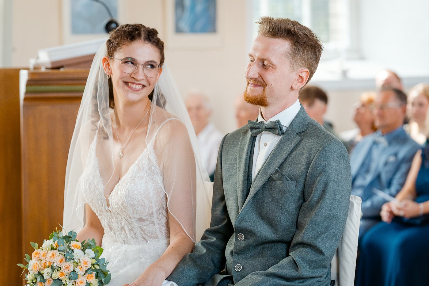 Kirchliche Trauung St. Petri Emmerstedt – Brautpaar lächelt sich während der Zeremonie wissend an, inniger vertrauter Moment, Hochzeitsfotografie St. Petri Emmerstedt Kathrin Skorpel