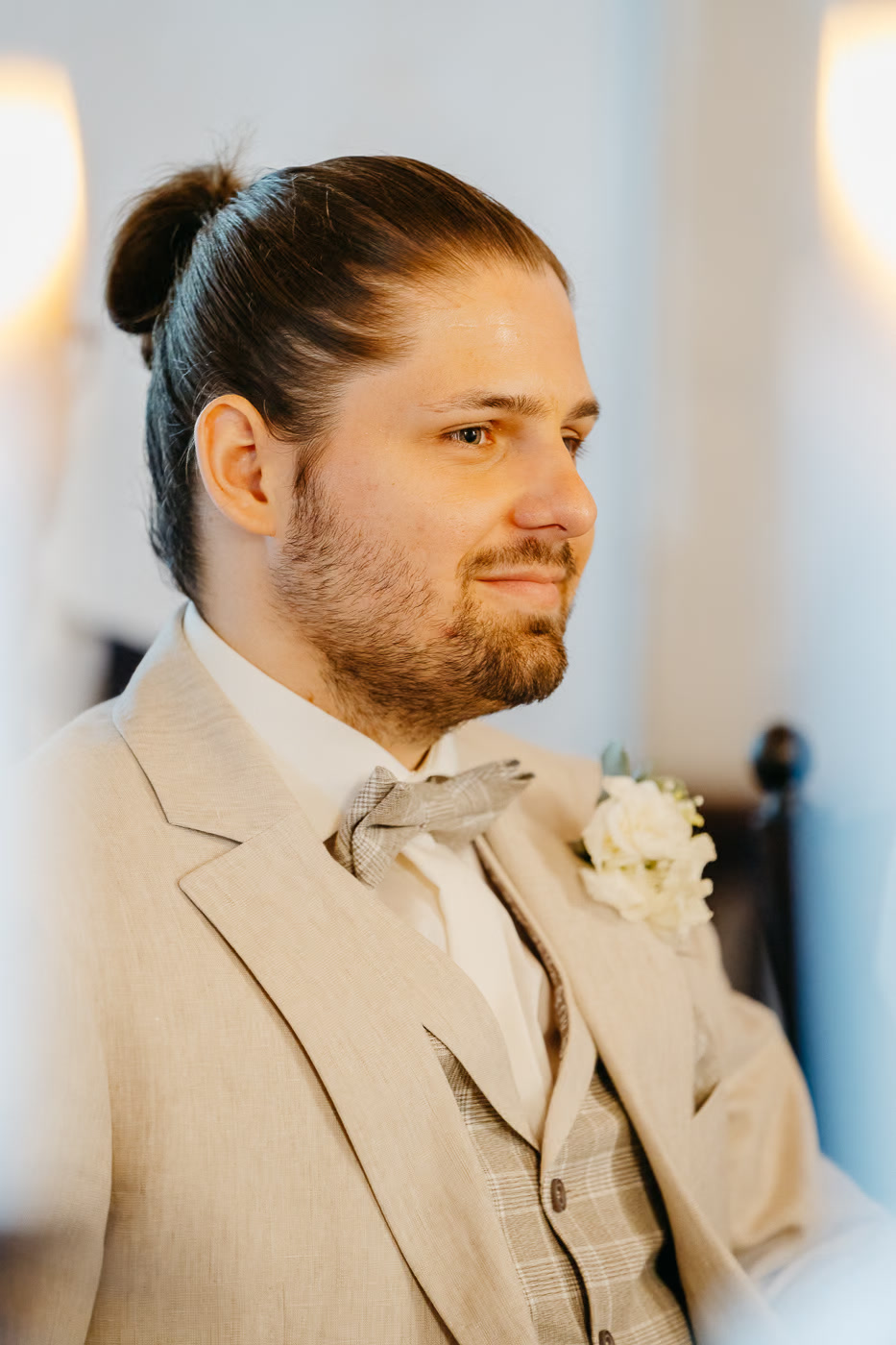 Standesamt Hochzeit Wolfenbüttel – Portrait Bräutigam im eleganten Beige-Anzug mit Dutt und Blick zur Seite, weiße Ansteckblume, warmes Kerzenlicht, Hochzeitsreportage Wolfenbüttel Kathrin Skorpel