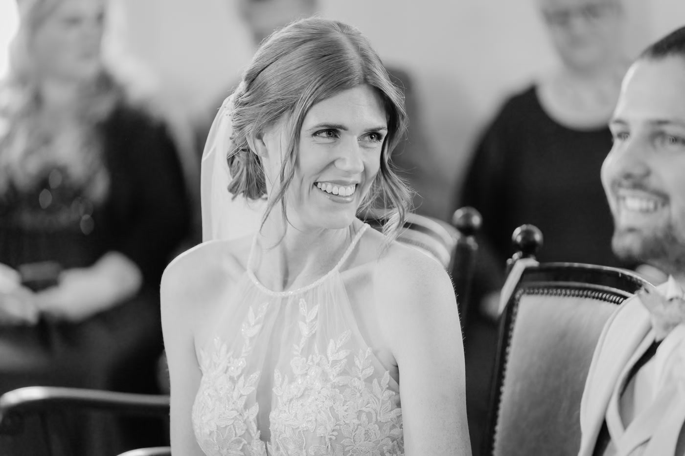 Standesamt Hochzeit Wolfsburg – Schwarz-Weiß Portrait strahlende Braut im Spaghettiträger-Kleid lacht herzlich während der standesamtlichen Zeremonie, pure Freude, Hochzeitsfotografie Wolfsburg Kathrin Skorpel